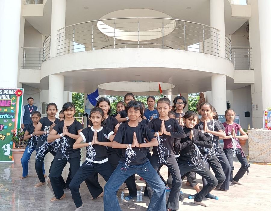 Students performing a dance in front of the school's columned entrance
