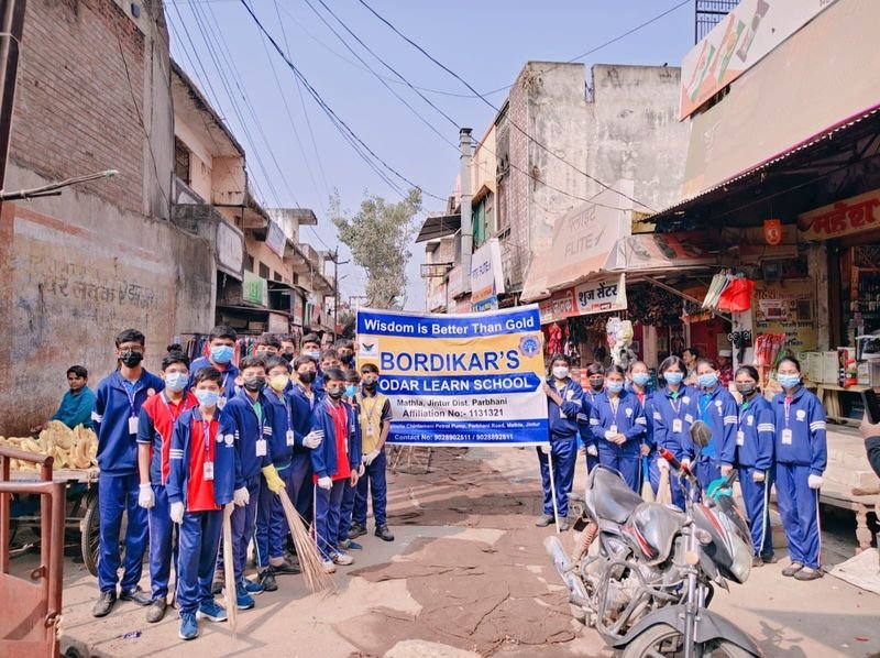 Students in a street rally holding the school banner