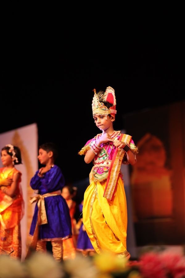 Student in traditional costume performing a solo on stage