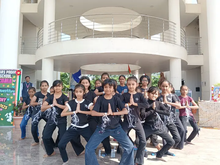 Students performing a dance in front of the school entrance