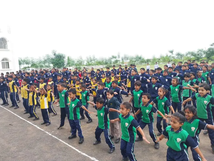 Students in house colours doing drill on the school ground