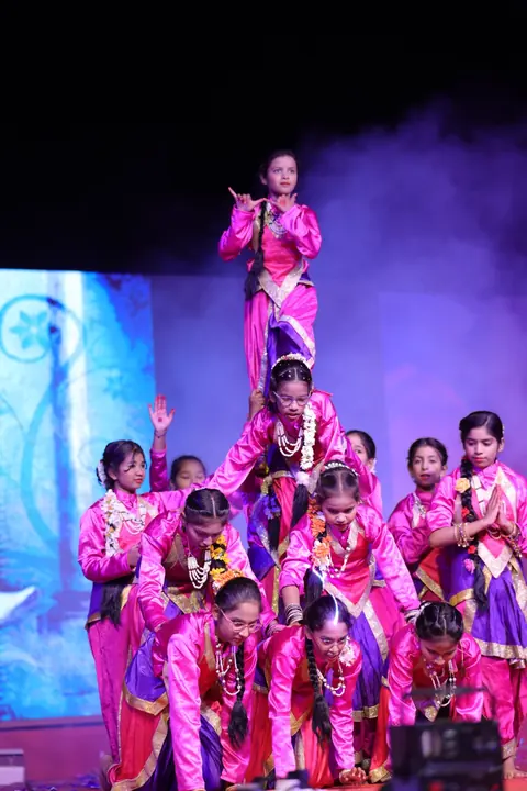 Girls in pink costumes forming a human pyramid on stage