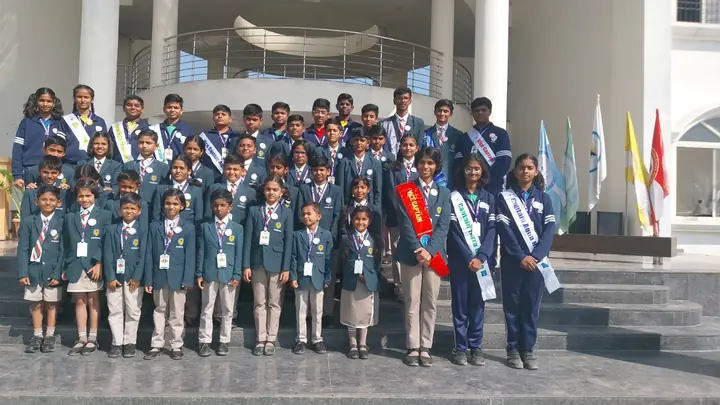 Student council members in blazers and sashes at the school entrance