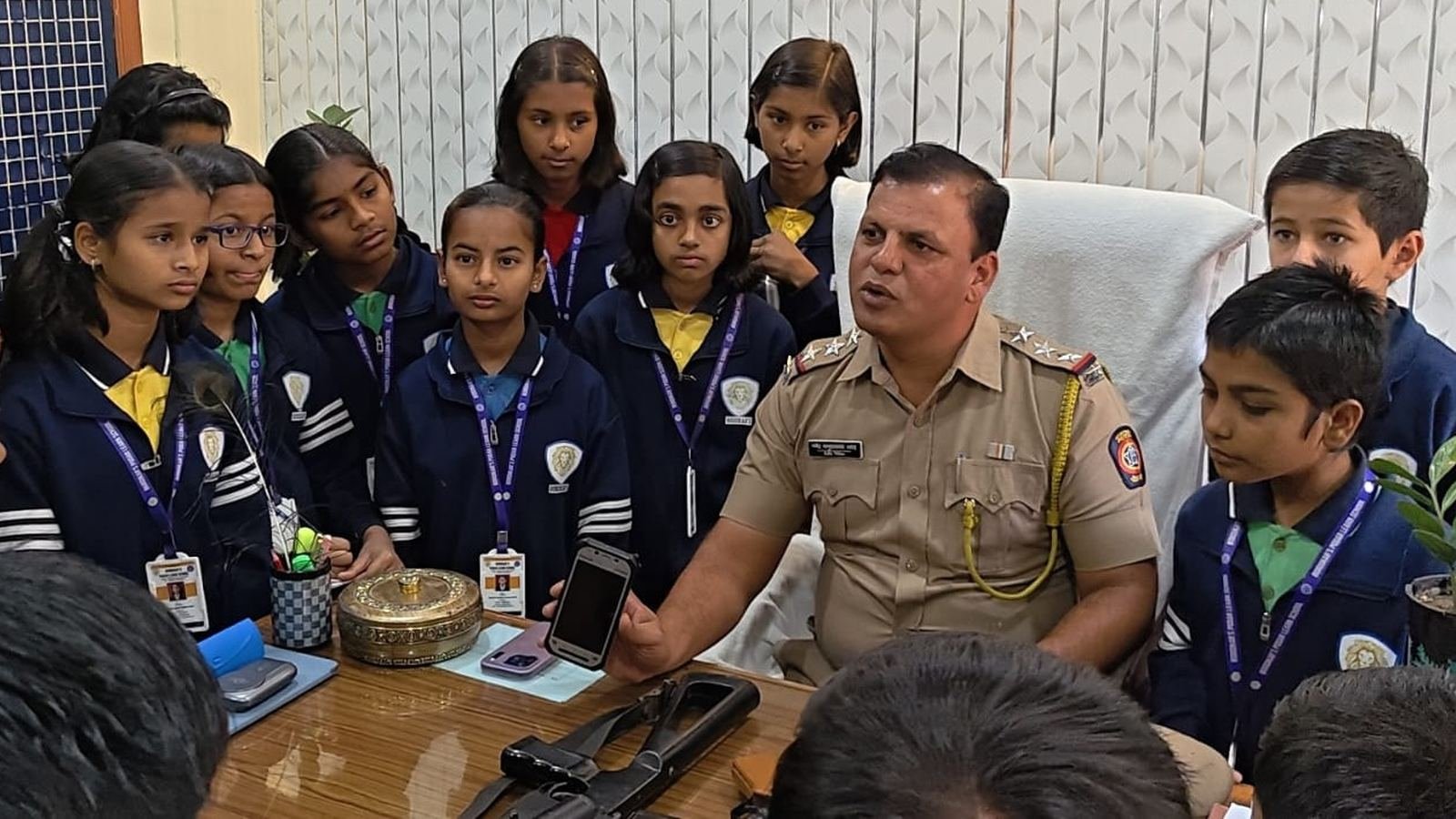 Students gathered around a police officer during a visit to the police station