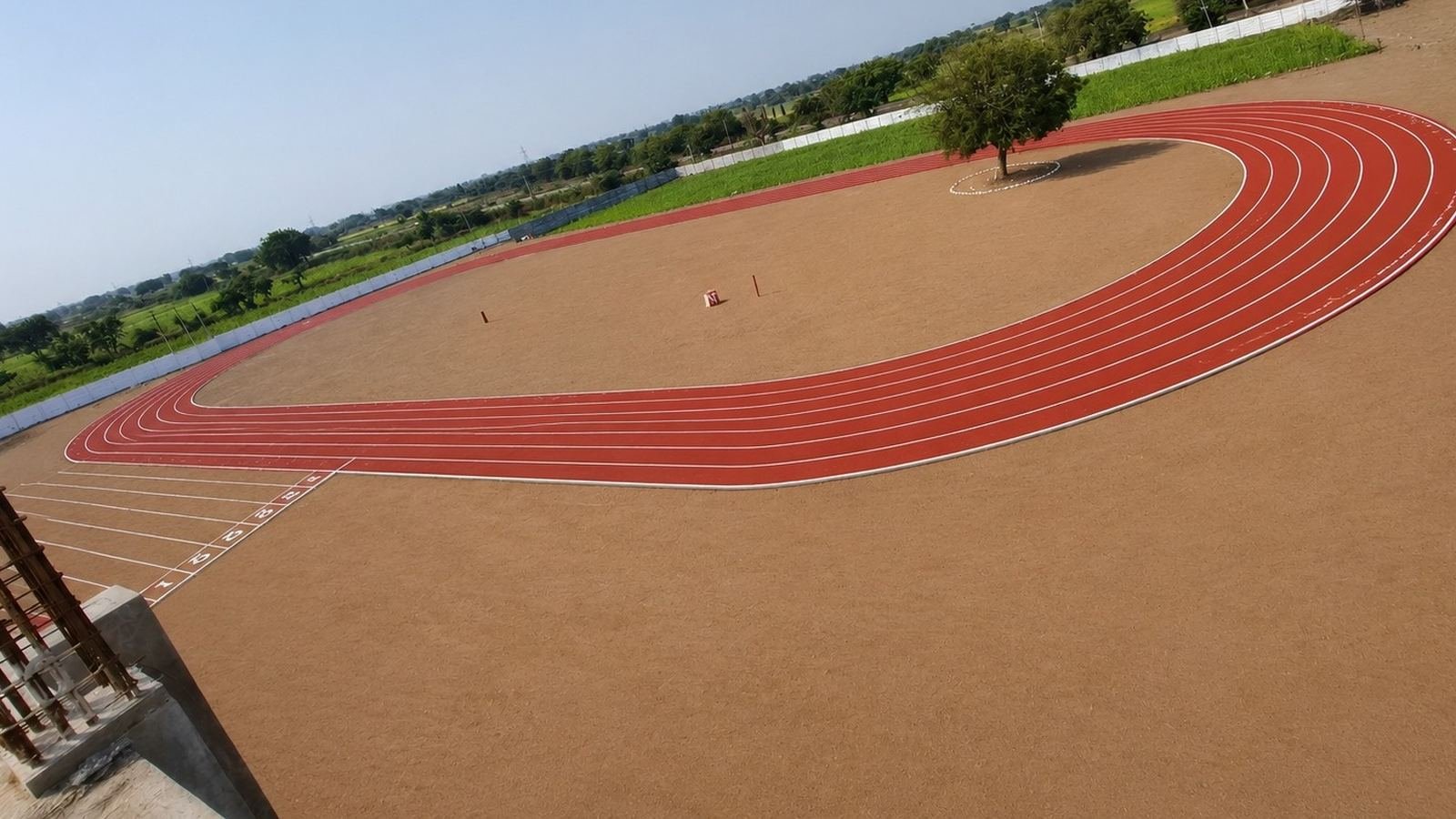 Red running track curving across the school campus