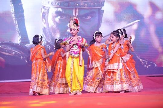 Young students performing as Krishna and gopis on stage