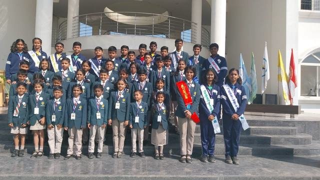 Student council in blazers and sashes at the school entrance
