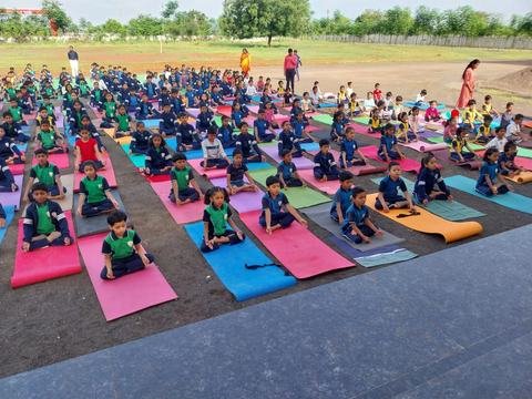 Students practising yoga on mats on the ground